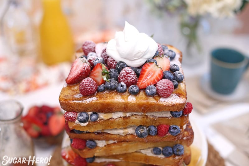 Close-up view of the French toast layer cake topped with fresh berries and whipped cream
