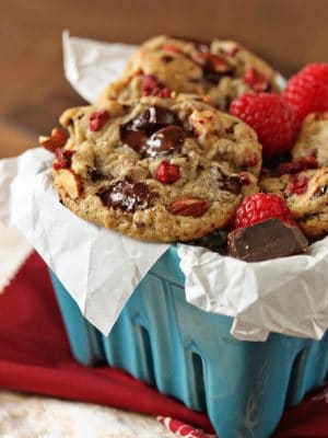 Close up of Raspberry Almond Chocolate Chunk Cookies in a light blue ceramic container.
