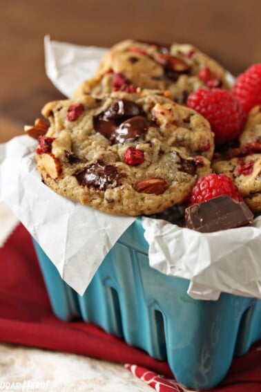 Close up of Raspberry Almond Chocolate Chunk Cookies in a light blue ceramic container.