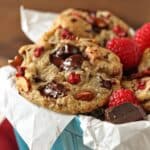 Close up of Raspberry Almond Chocolate Chunk Cookies in a light blue ceramic container.