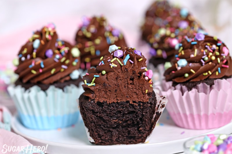 Picture of a homemade chocolate cupcake with a bite taken out of it, showing the moist texture inside