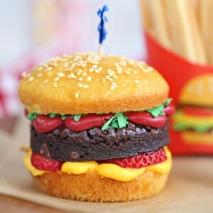 Close-up of hamburger cupcake on brown parchment paper.
