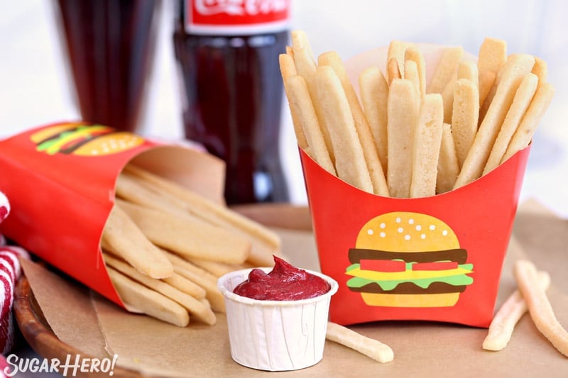 Two cups of Sugar Cookie French Fries, with frosting "ketchup" in a paper cup in between