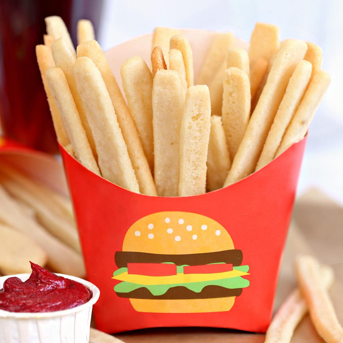 Sugar Cookie French Fries in red french fry container with frosting "ketchup" on the side.