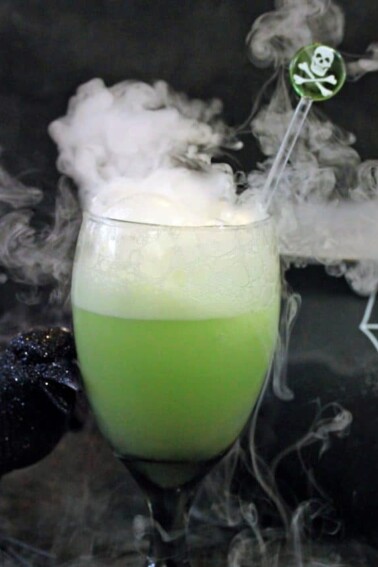 Halloween punch bubbling in a green glass goblet.