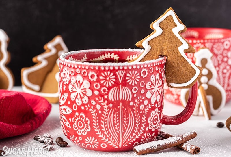 Tree-shaped Gingerbread Cookie Mug Topper on the edge of a red and white mug