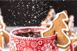 Tree-shaped Gingerbread Cookie Mug Topper with powdered sugar being sprinkled on with overlay text for Pinterest