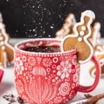 Tree-shaped Gingerbread Cookie Mug Topper on the edge of a red and white mug