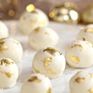 Champagne White Chocolate Truffles on a white marble tray with gold decorations in the background