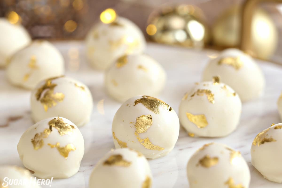 Champagne White Chocolate Truffles on a white marble tray with gold decorations in the background