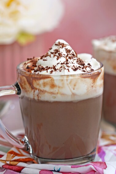 Mug of slow cooker hot chocolate with whipped cream and chocolate shavings on top