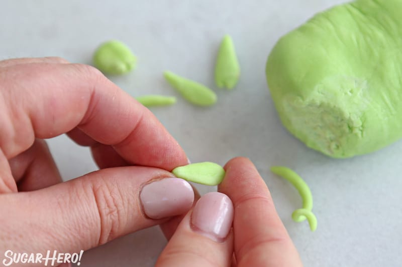 Hand forming a small petal out of green fondant