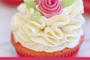 Photo of frosted cupcake with fondant flowers and text overlay for Pinterest