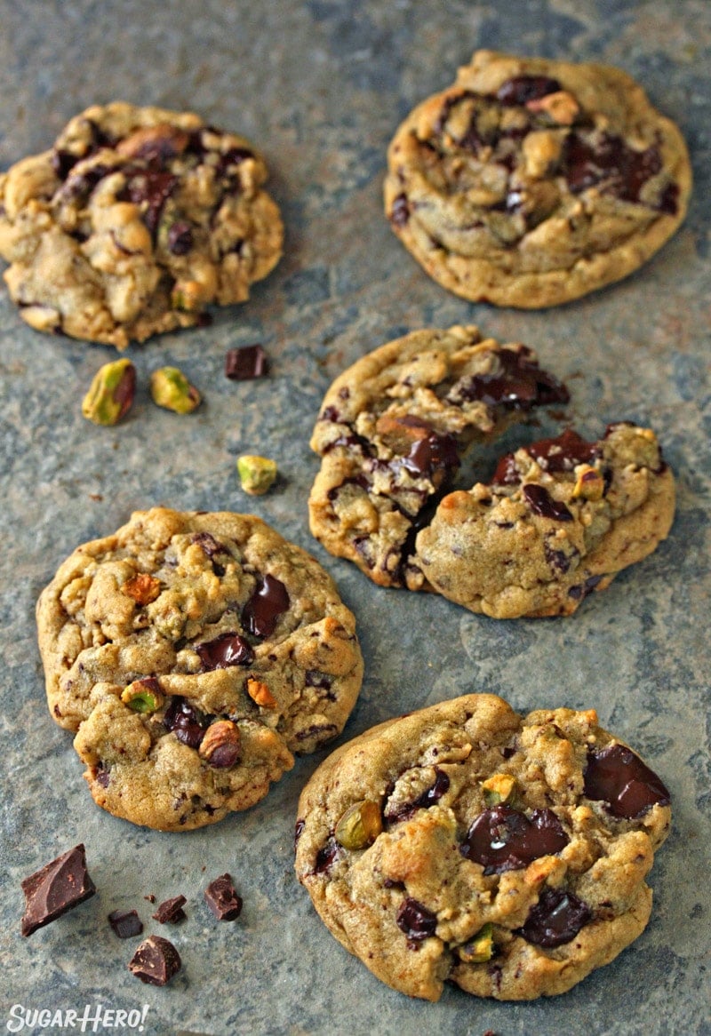 Five Pistachio Chocolate Chunk Cookies on a blue tile