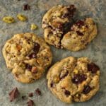 3 Pistachio Chocolate Chunk Cookies with top cookie broken in half.