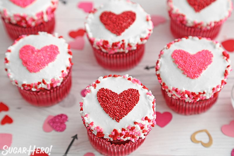 Group of cupcakes with red and pink hearts made of sprinkles in the center