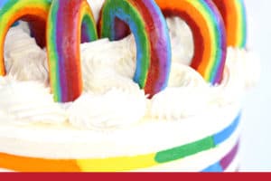 Buttercream Rainbows on rainbow striped cake with text overlay for Pinterest