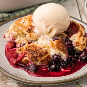 Close-up of Mixed Berry Cobbler with melting vanilla ice cream on top