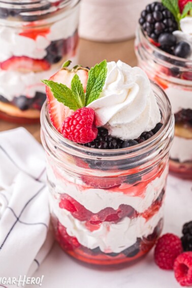 Mixed Berry Shortcake in a Jar with whipped cream and mint on top