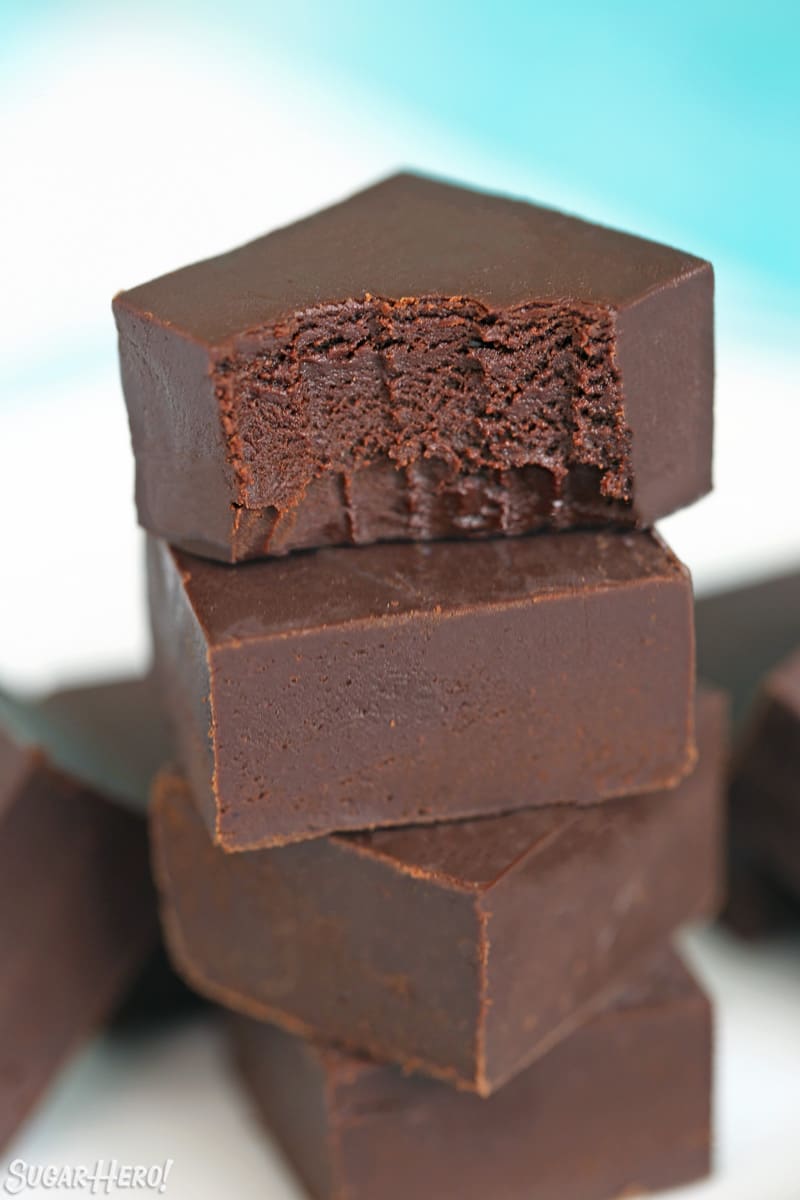 Hand lifting a piece of chocolate fudge off a stack