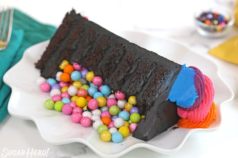 Slice of chocolate cake with colorful candy in front