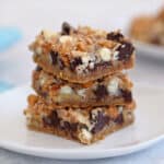 A stack of 3 Seven Layer Bars on a small white plate.