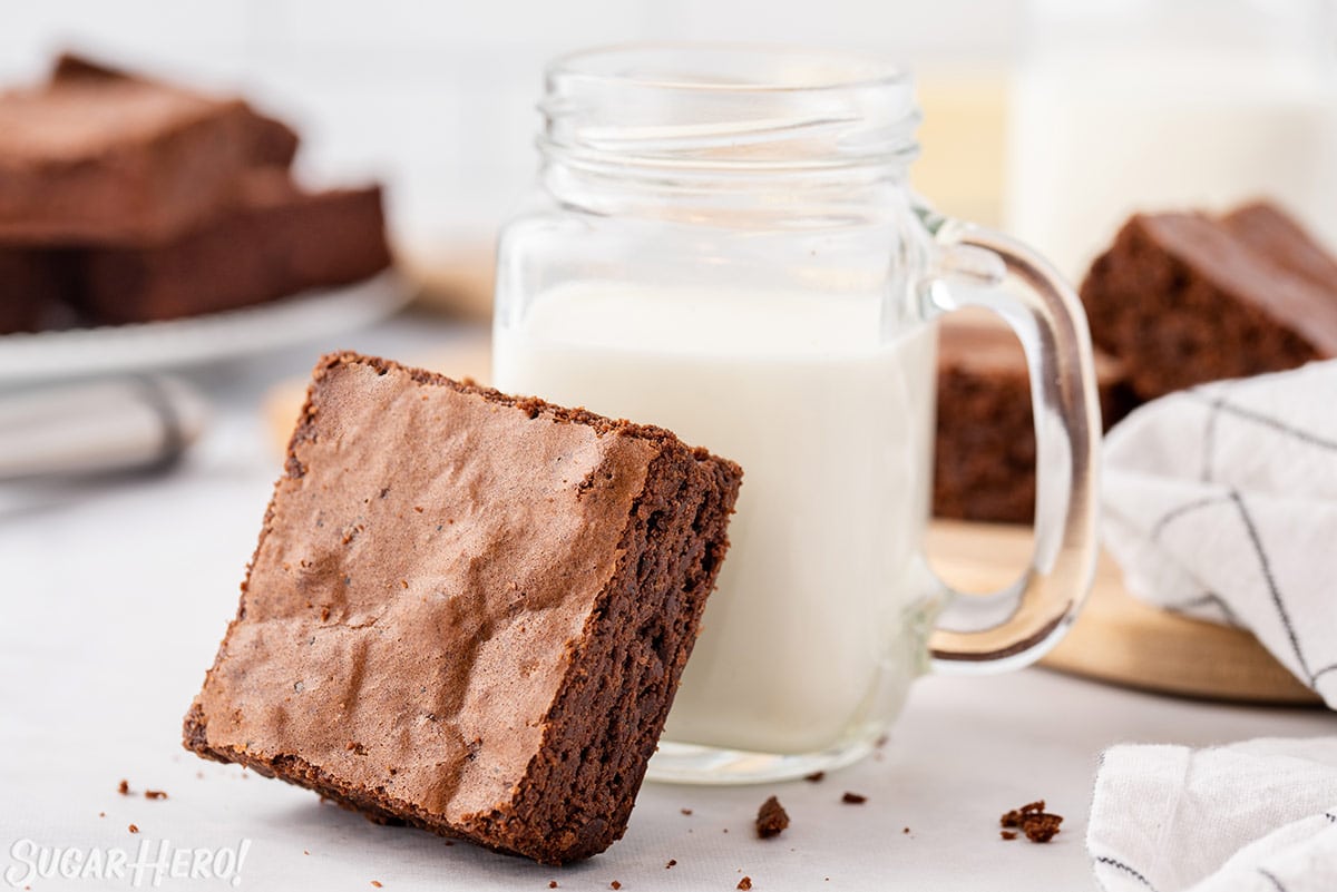 Brown Butter Brownie leaning against a mason jar of milk