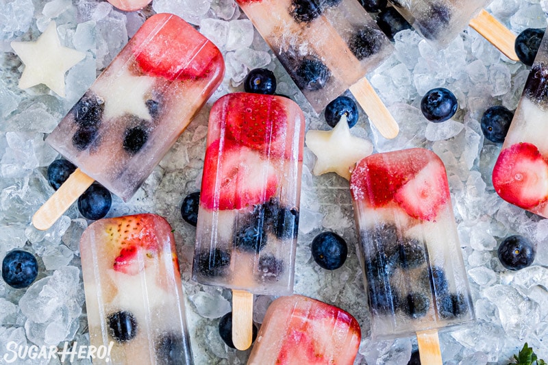 Homemade Fruit Popsicles with pieces of fruit inside on a bed of ice