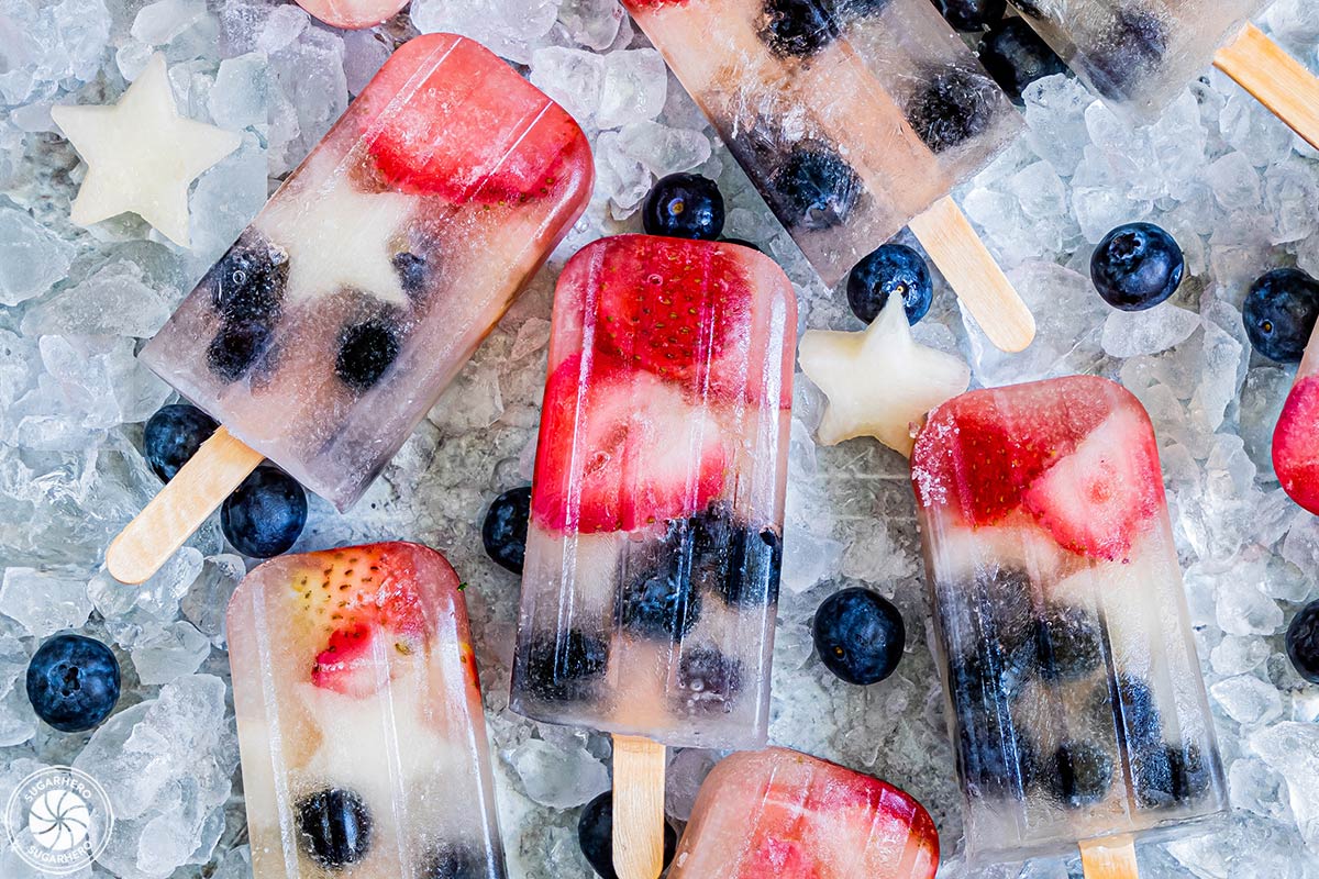 Homemade Fruit Popsicles with pieces of fruit inside on a bed of ice