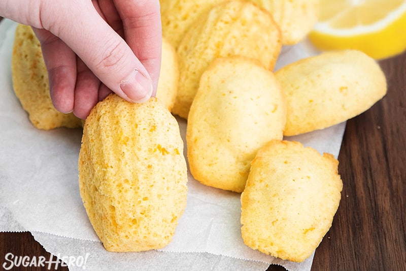 Hand picking up a Lemon Madeleine from a cutting board