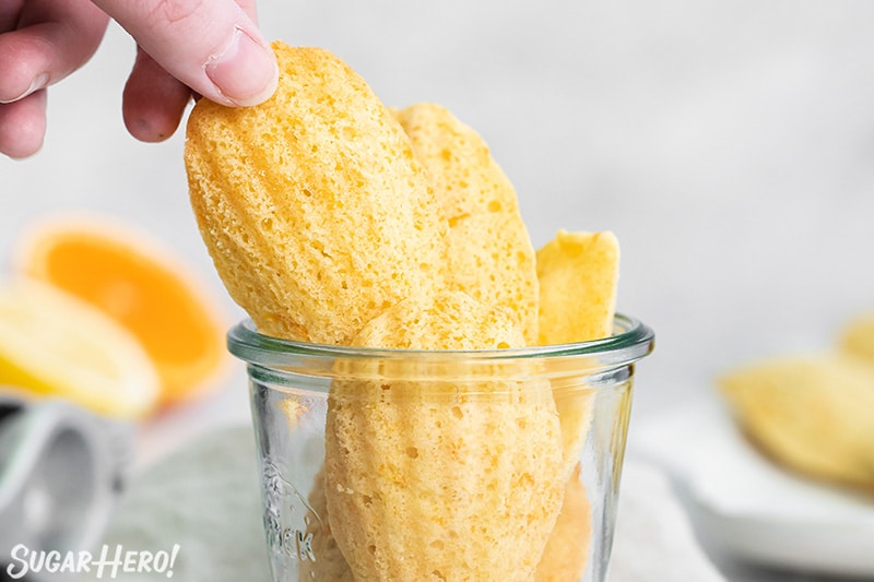Hand pulling a Lemon Madeleine out from a clear jar