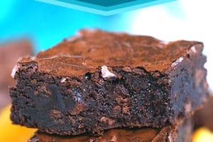 Stack of three chocolate orange brownies with a bite out of the top brownie.