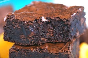 Stack of three chocolate orange brownies with a bite out of the top brownie.