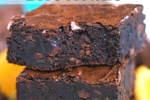 Stack of three chocolate orange brownies with a bite out of the top brownie.