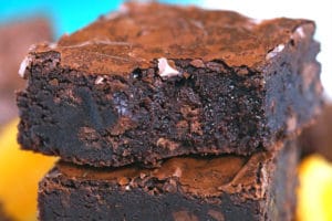 Stack of three chocolate orange brownies with a bite out of the top brownie.