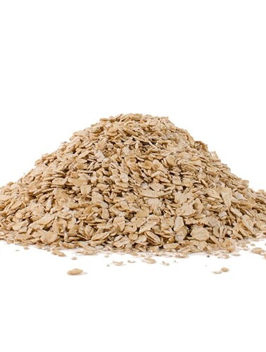Rolled oats in a pile on a white surface.