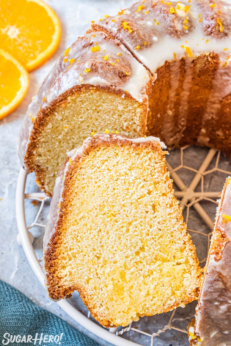 Sliced bundt cake on a wire rack with one piece leaning to the side.