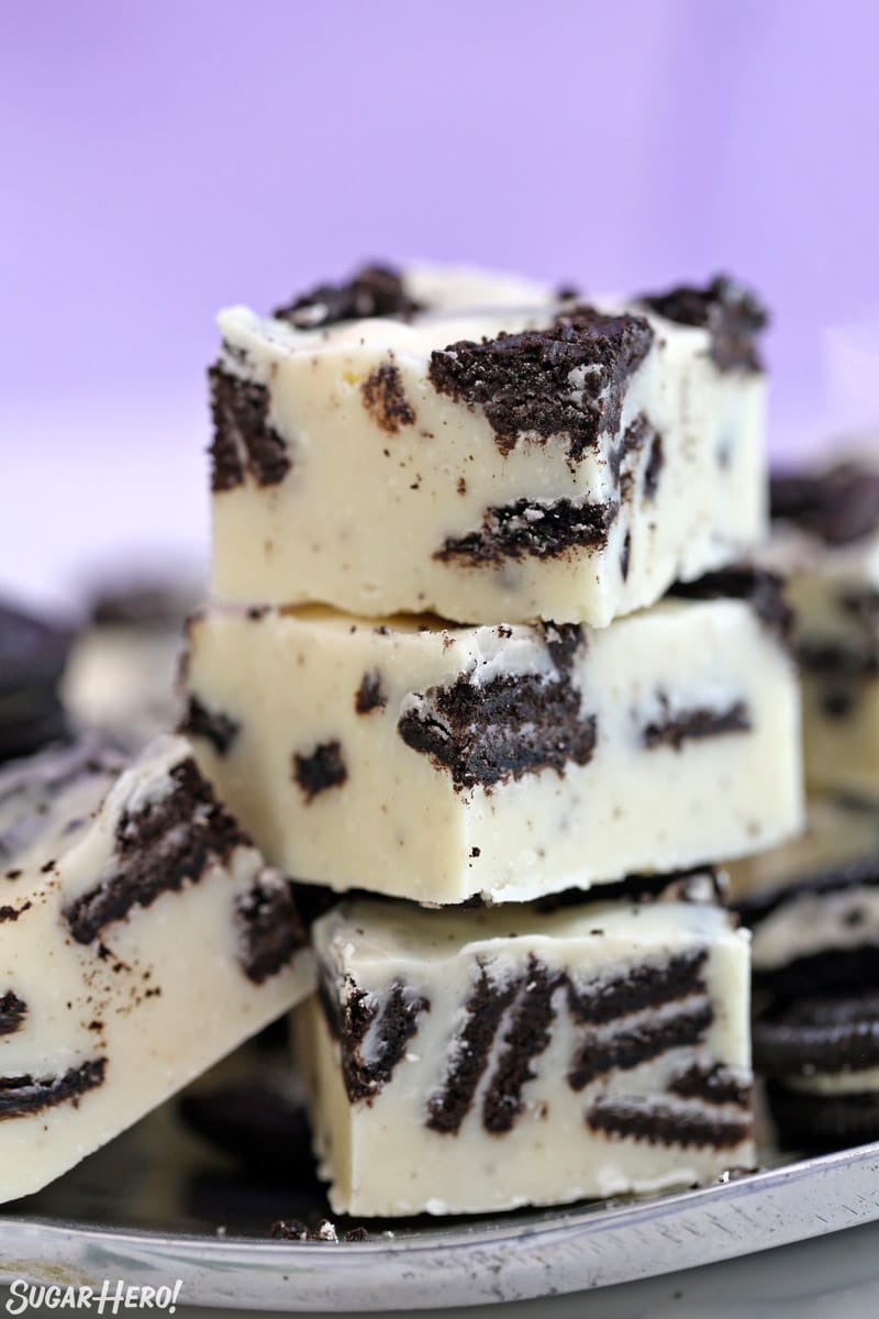 Three stacked pieces of Oreo Fudge on a silver plate.