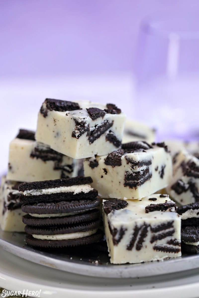 Oreo Fudge on a purple plate with Oreo cookies stacked nearby.