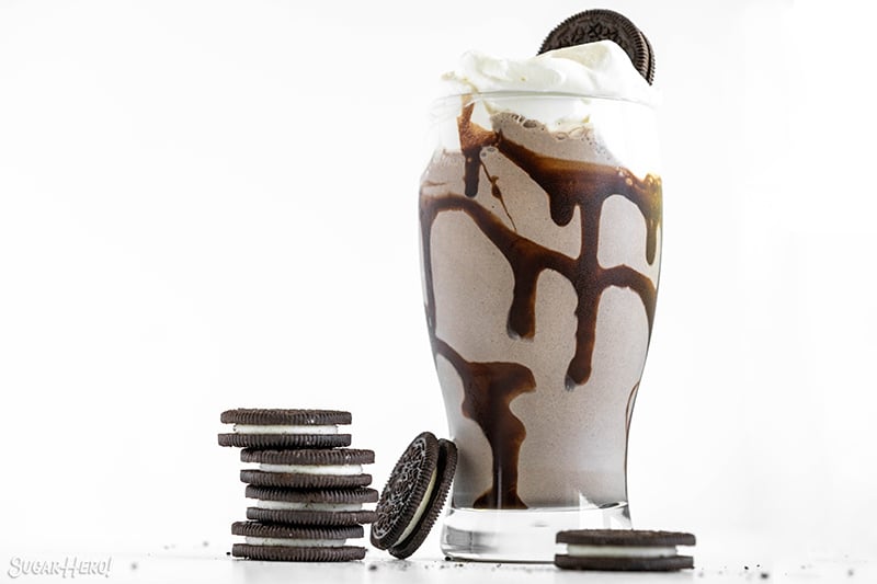 Glass filled with Oreo Milkshake and topped with whipped cream and an Oreo cookie.