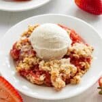 Close-up of Strawberry Crisp with a scoop of vanilla ice cream on top.