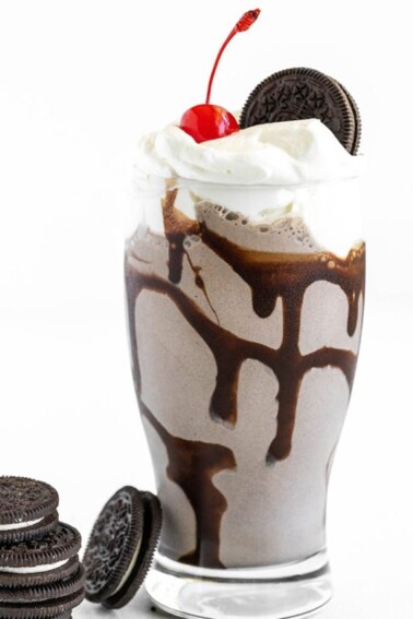 Oreo milkshake with whipped cream and a cherry on top.