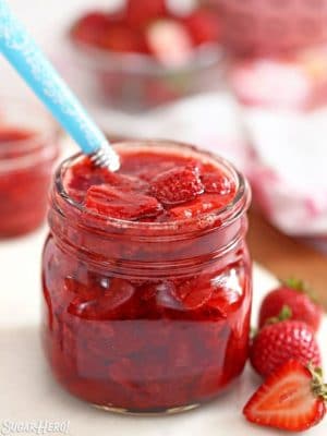 Jar of Strawberry Sauce with blue spoon sticking out.