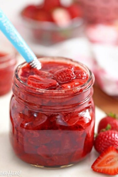 Jar of Strawberry Sauce with blue spoon sticking out.