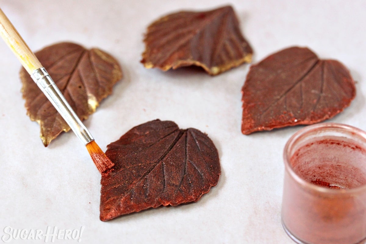 Brushing luster dust on a chocolate leaf.