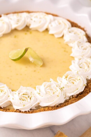 Close-up of Key Lime Pie with whipped cream rosettes around the edge.