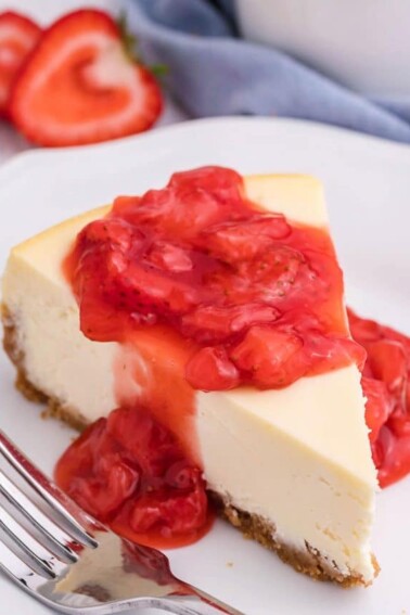 Slice of cheesecake with strawberry sauce on it.