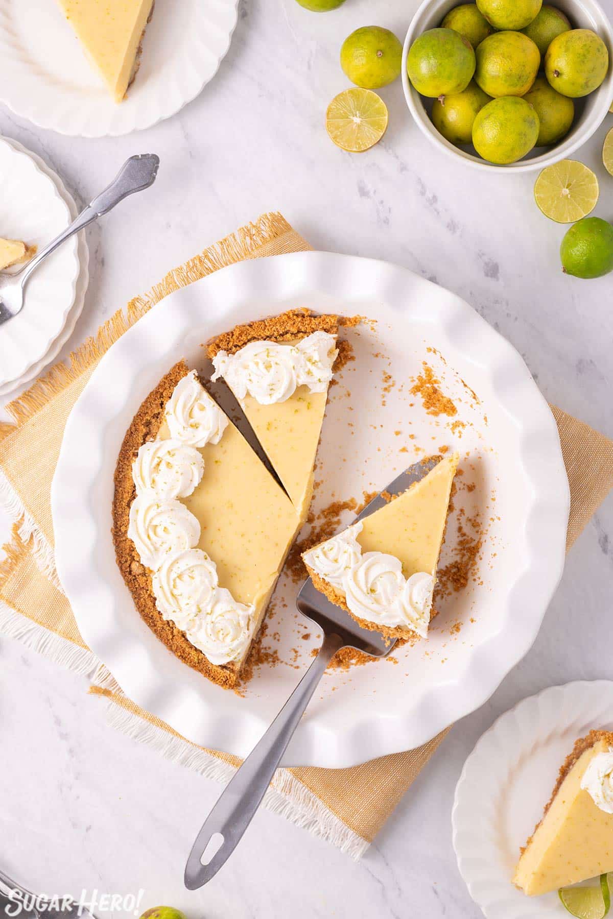 Overhead shot of Key Lime Pie with several slices removed and a pie server holding one slice.