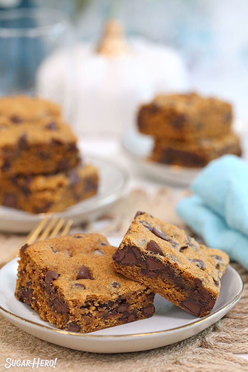 Pumpkin Chocolate Chip Bars on a white plate with more bars stacked in the background.