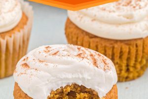 Three pumpkin spice cupcakes, one with a bite missing and the words "Pumpkin Cupcakes" above the photo.